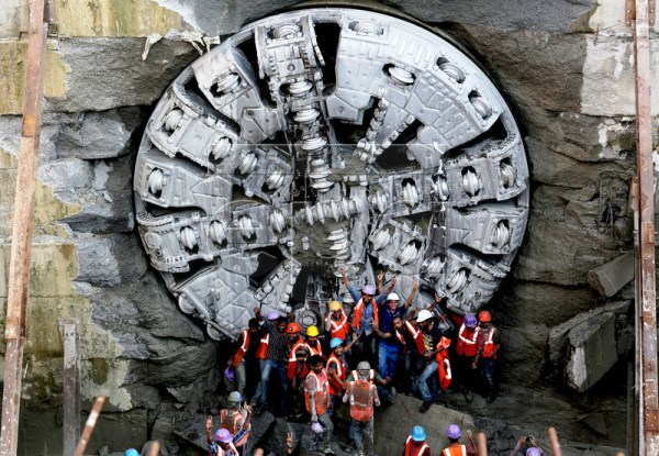 Workers pose for photos in front of Krishna - Photo Copyright: European Pressphoto Agency